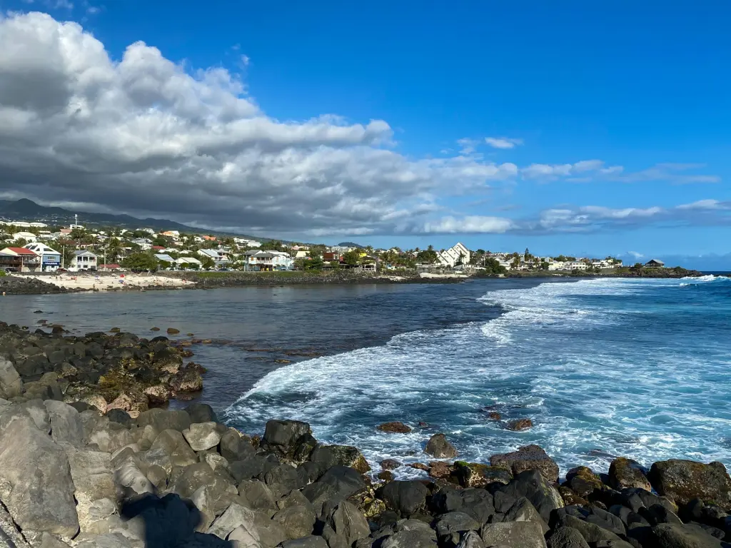 Côte rocheuse et vagues devant une petite ville au pied des montagnes