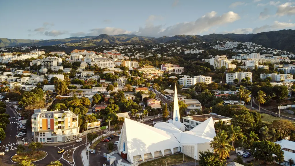 Vue aérienne d'une ville avec une église blanche, au pied des montagnes